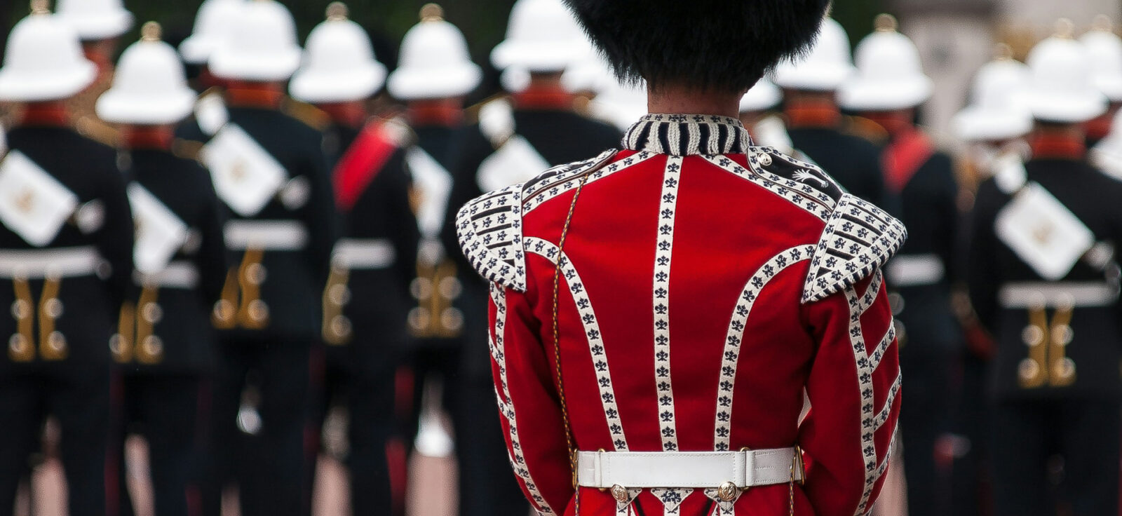 des hommes en tenue militaire rouge defilent