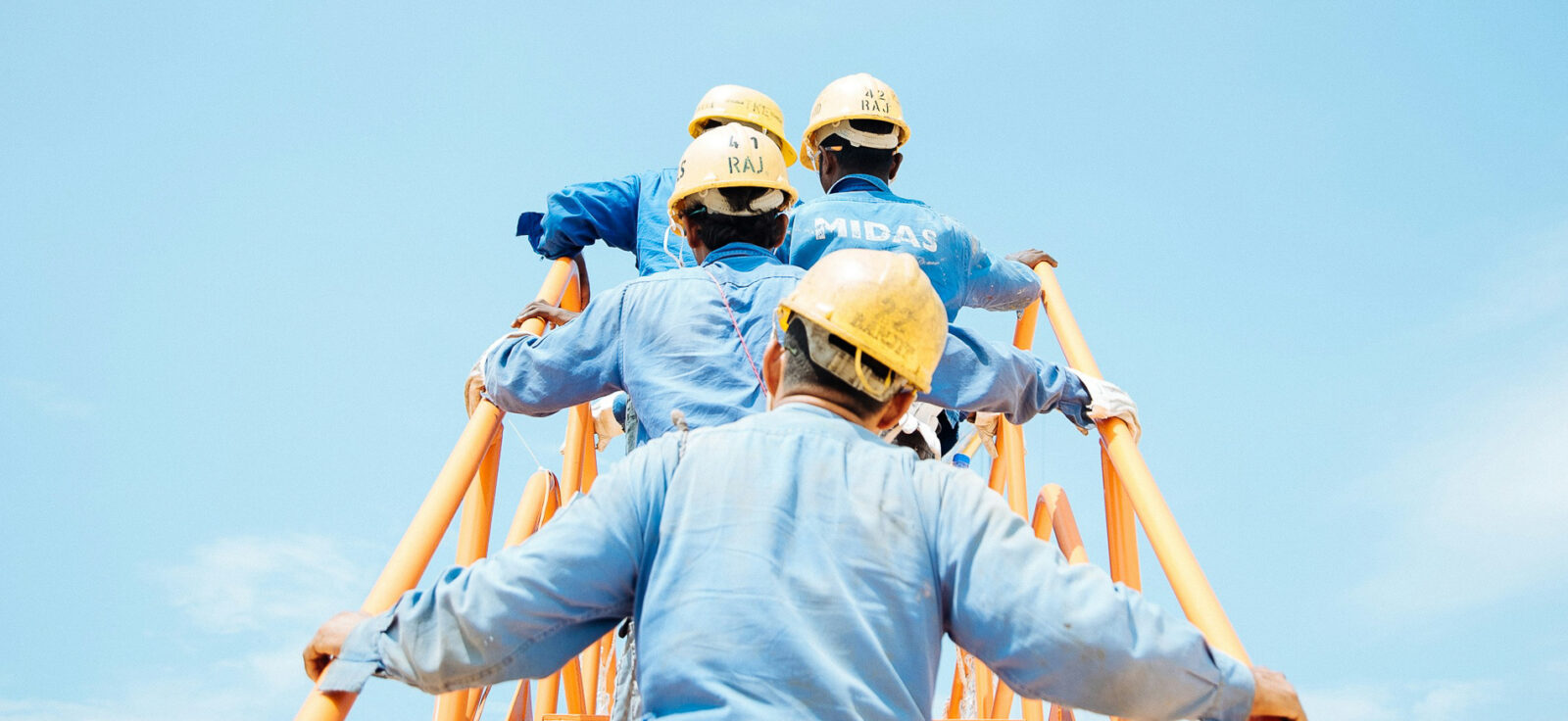 travailleurs en casques jaunes montent un escalier