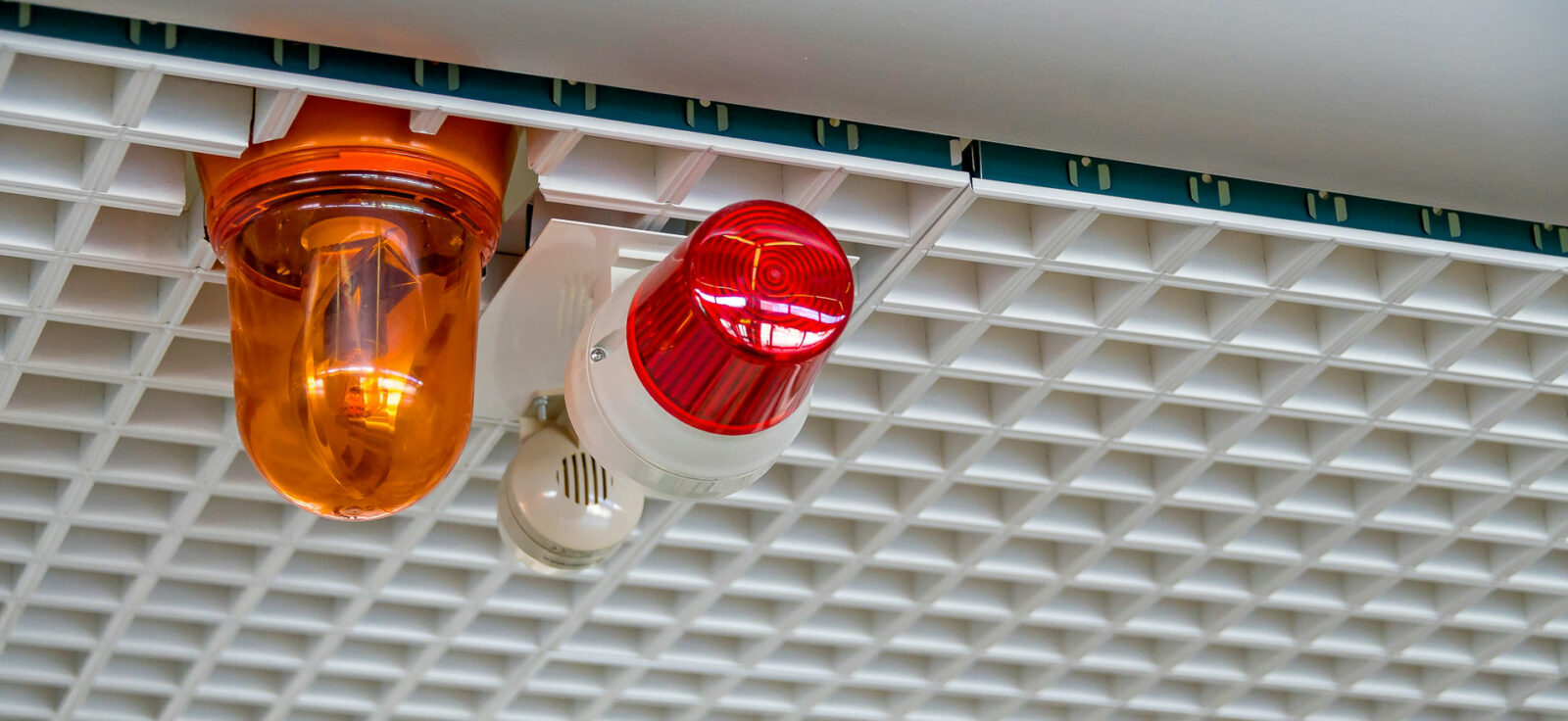 2 alarmes attachées à un plafond blanc
