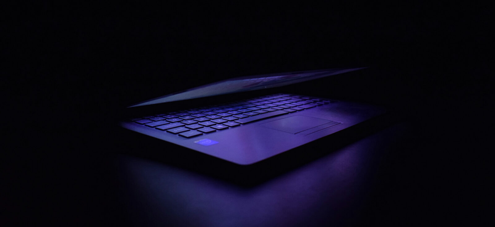 Ordinateur avec le capot à moitié fermé, tons violets