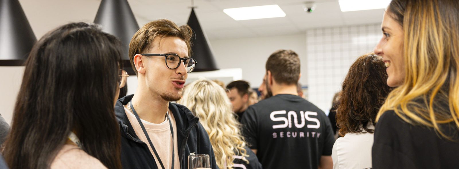 des collaborateurs SNS Security qui discutent lors d'un événement de communication interne