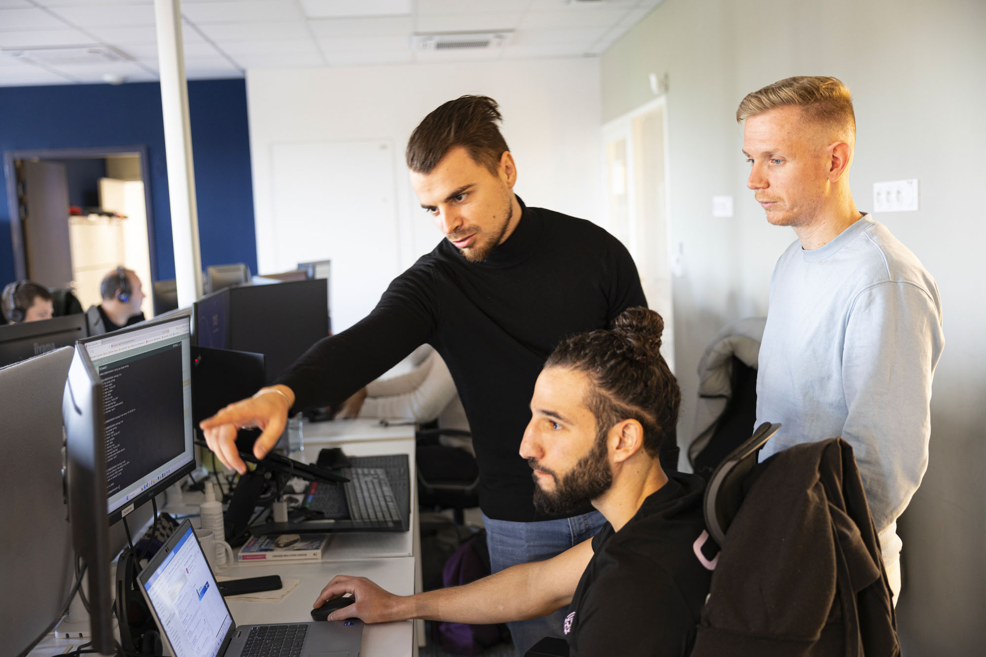 trois techniciens support SNS Security échangeant devant un ordinateur