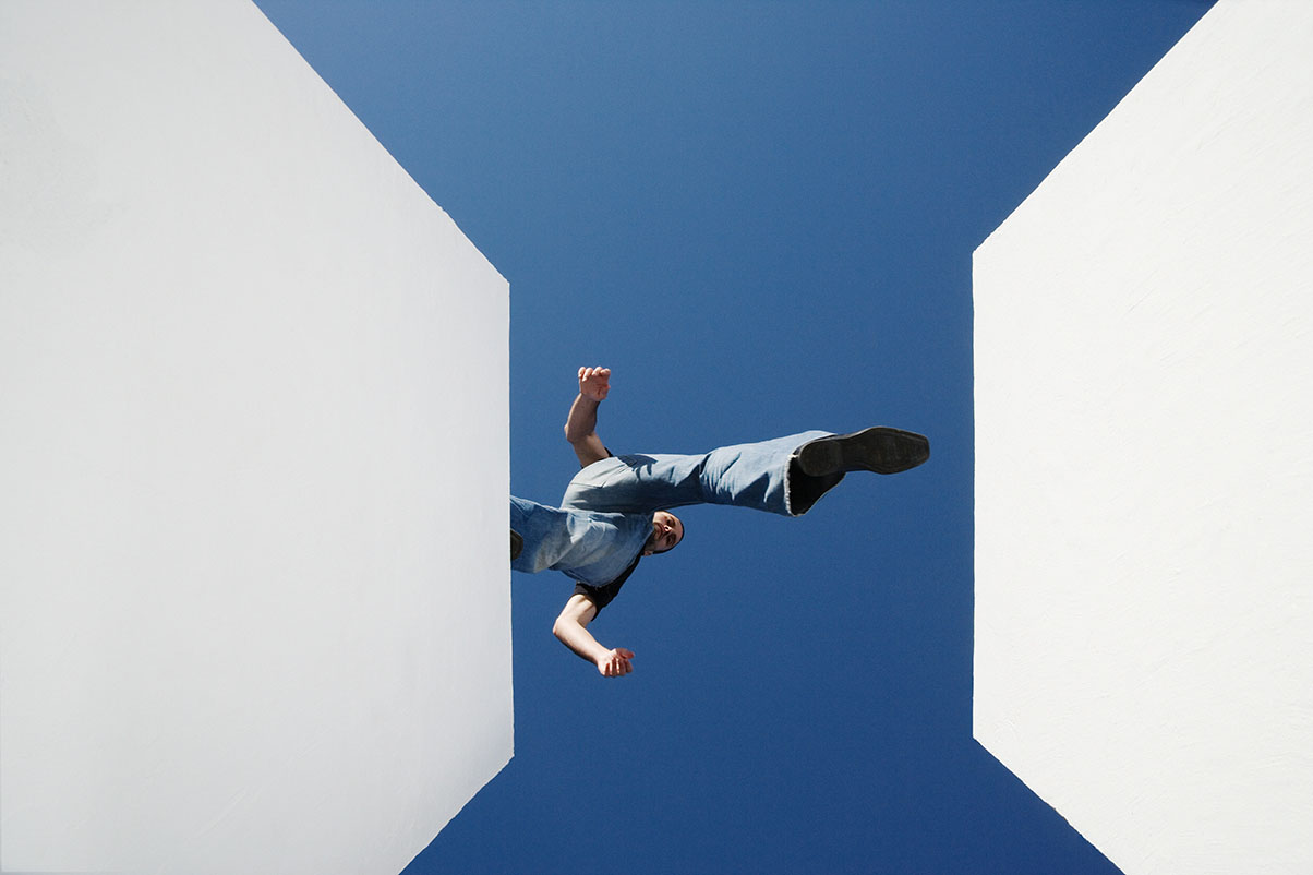 vue du dessous d'une personne dans le vide vide enjambant deux bâtiments blancs