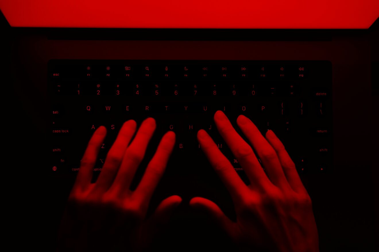 Main posées sur un clavier avec une lumière rouge