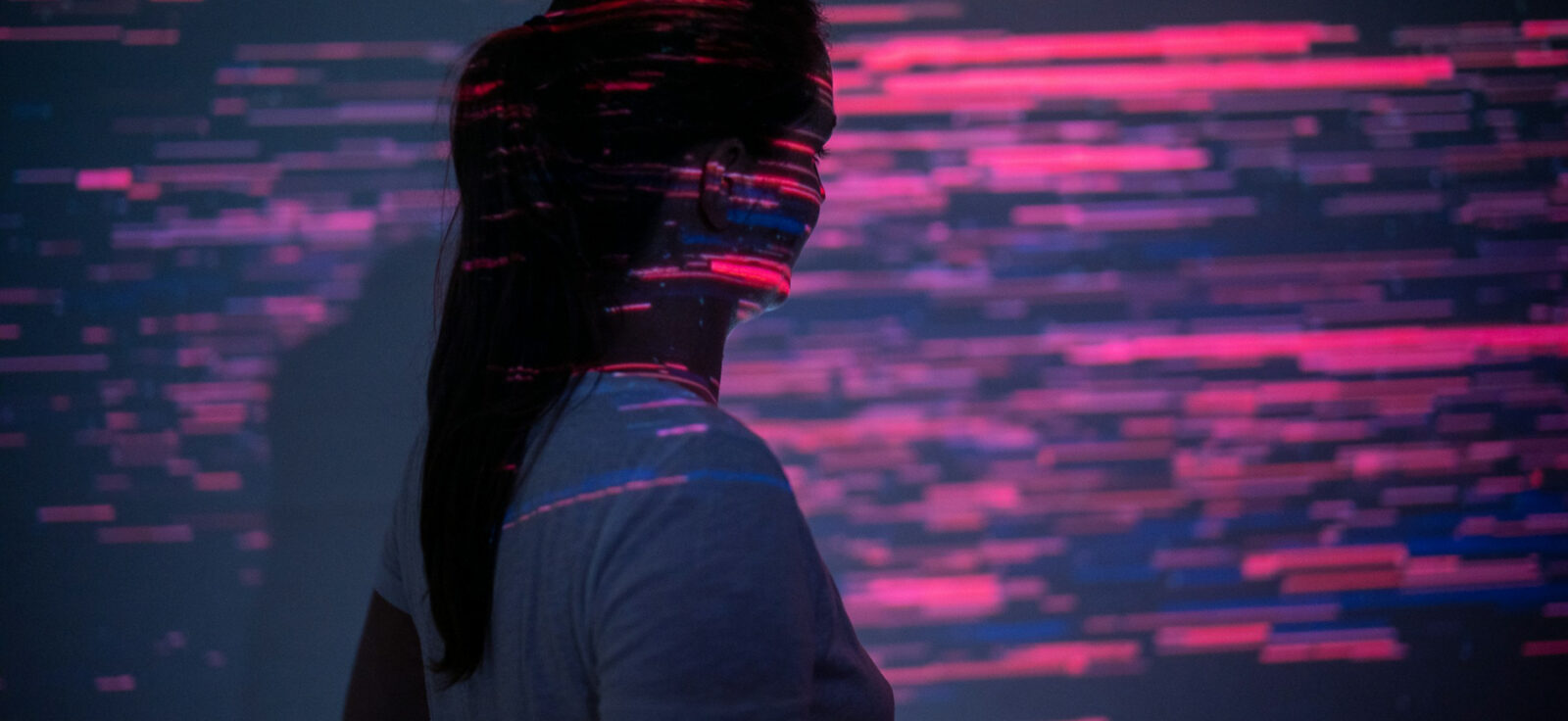 femme regardant une projection abstraite de traits rouges et violets